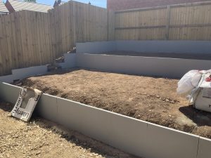 Three-tier sloping garden with paving, artificial grass and white cobbles, Stone