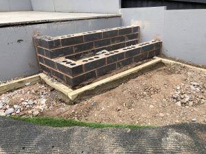 Three-tier sloping garden with paving, artificial grass and white cobbles, Stone