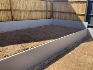 Three-tier sloping garden with paving, artificial grass and white cobbles, Stone