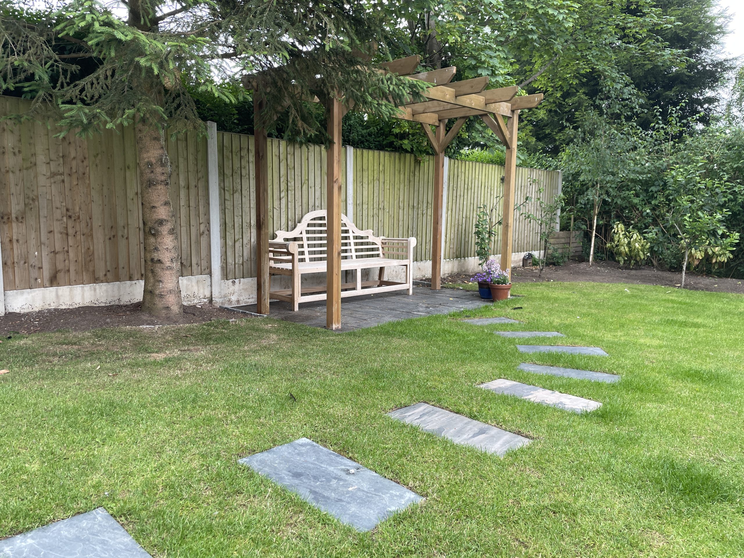 Planter border edged with stone blocks beside a new slate patio, Stone