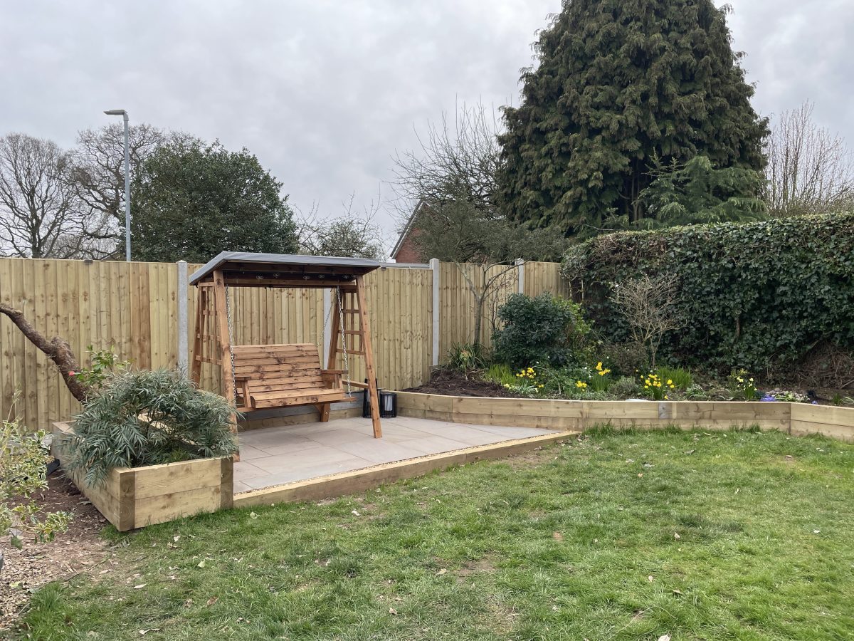 Finished 30m² Raj Green Indian stone patio with green sleeper retaining wall, Stone, Staffordshire