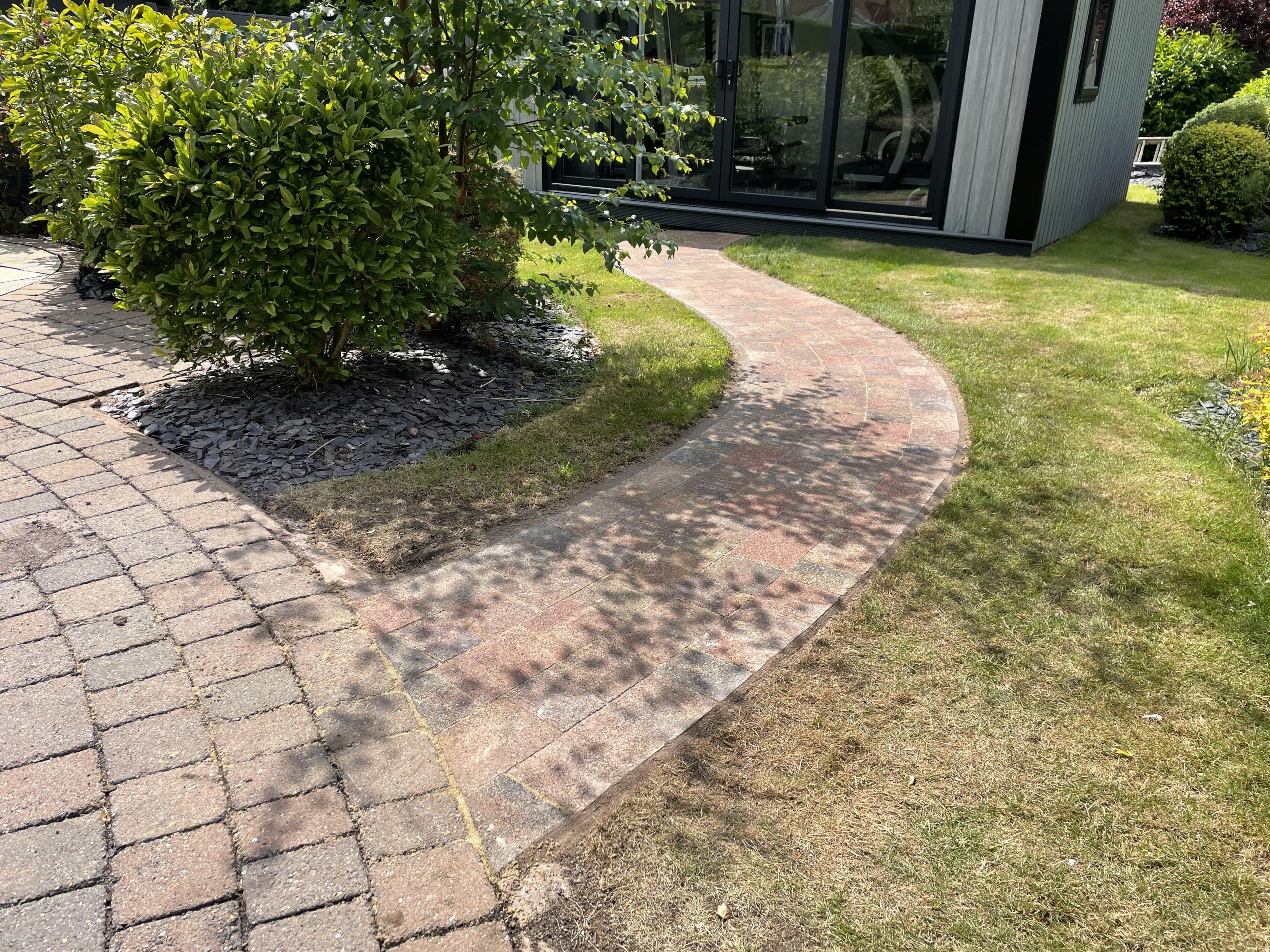 Red and brown block paved pathway leading to a garden gym, Stone, Staffordshire