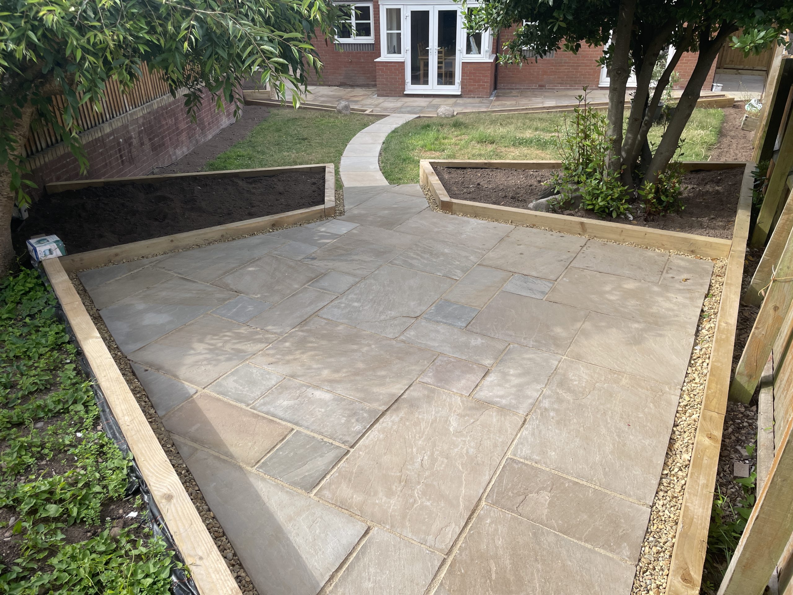 Finished garden with Autumn Blend natural stone patios and sleeper planters, Stone, Staffordshire