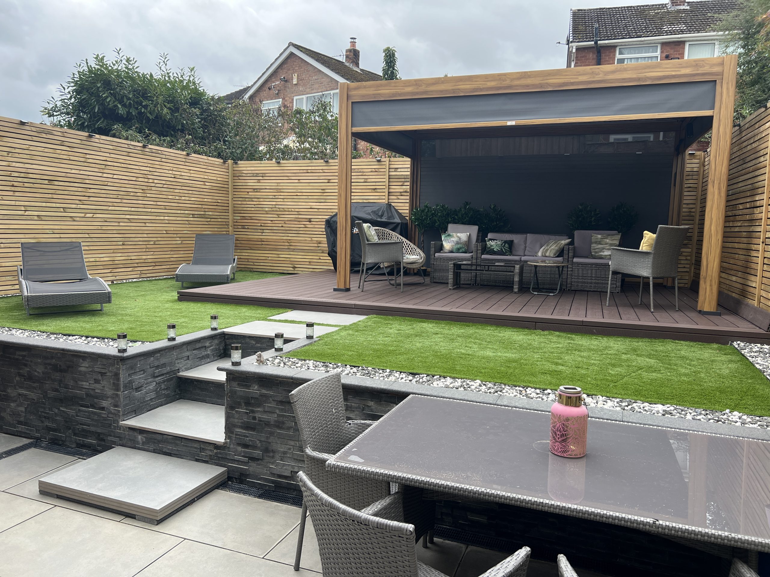 Finished garden with composite decking, porcelain patio, artificial grass, granite wall cladding and Venetian fencing, Tittensor